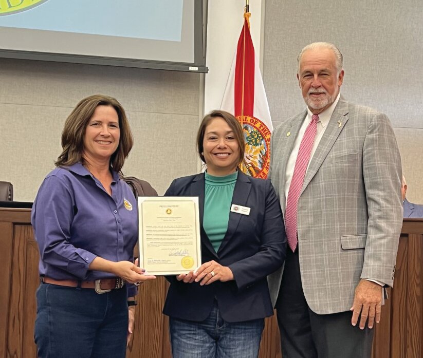 OKEECHOBEE -- (Left to right) Robbi Sumner and Audrey Kuipers accept the National Association of Conservation Districts Stewardship Week Proclamation from Commissioner Terry Burroughs at the April 27 meeting of the Okeechobee County Commission.